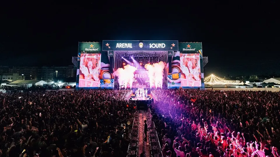 Miles de personas frente al escenario principal de Arenal Sound, con el rótulo del festival iluminado y llamaradas de humo durante el concierto nocturno de Bresh