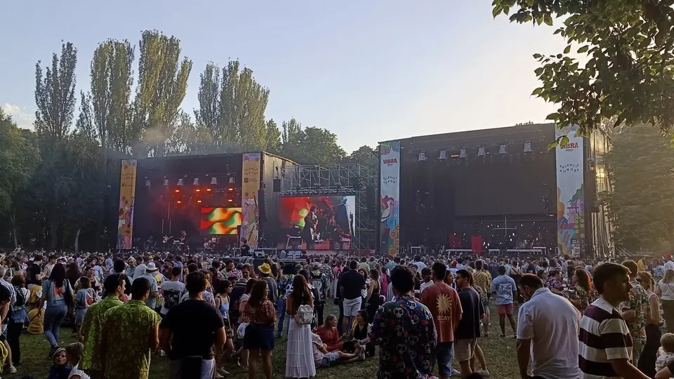 Público de Palencia Sonora 2026 en el parque del Sotillo de Palencia al atardecer, frente a los dos escenarios principales del festival con sus lonas de colores