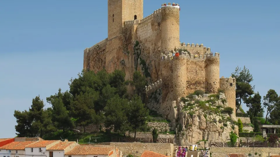 Castillo de Almansa sobre su peñón rocoso, con la muralla almenada y la torre del homenaje recortadas contra el cielo
