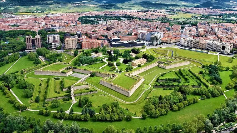 Vista aérea de la Ciudadela de Pamplona: la fortaleza en forma de estrella, con sus baluartes rodeados de césped y arbolado, en medio de los edificios del centro de la ciudad