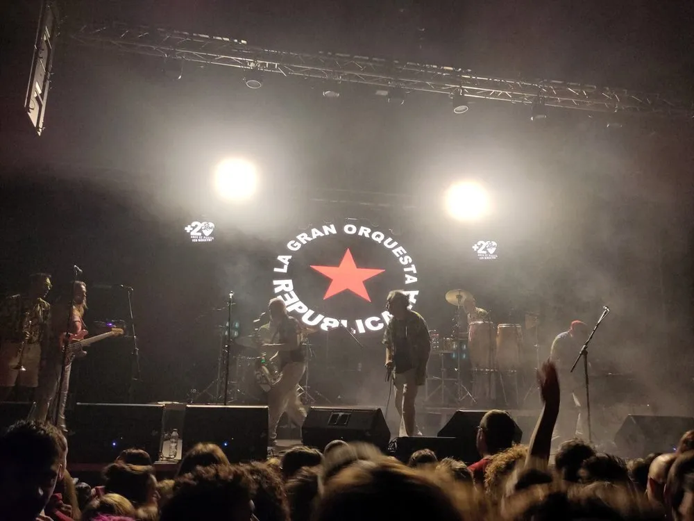Concierto en una sala de Es Gremi, en Palma, con el logotipo de La Gran Orquesta Republicana iluminado al fondo del escenario y el público en primer plano