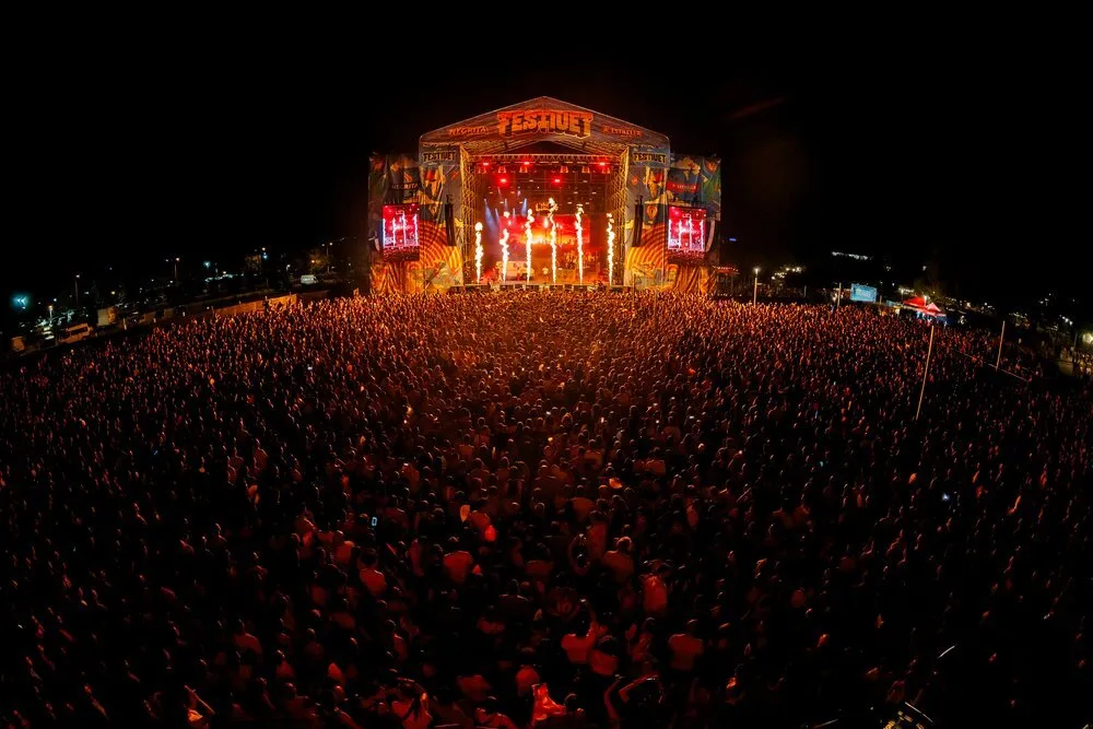 Vista general nocturna de Festiuet 2026 en Salou, con miles de personas ante el escenario iluminado en rojo y columnas de fuego en el escenario