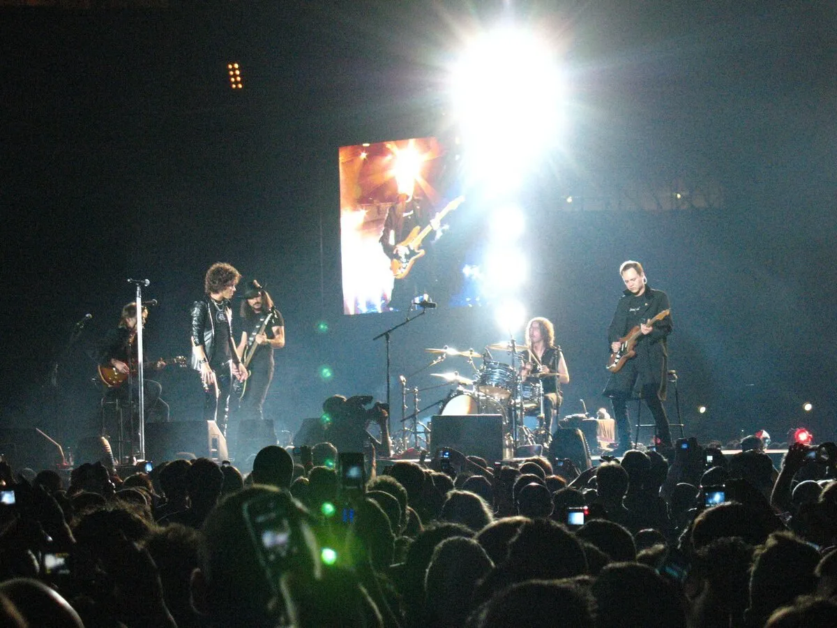 Héroes del Silencio sobre el escenario durante un concierto de su gira de reunión de 2007 en Sevilla, con el público en primer plano y una pantalla gigante al fondo