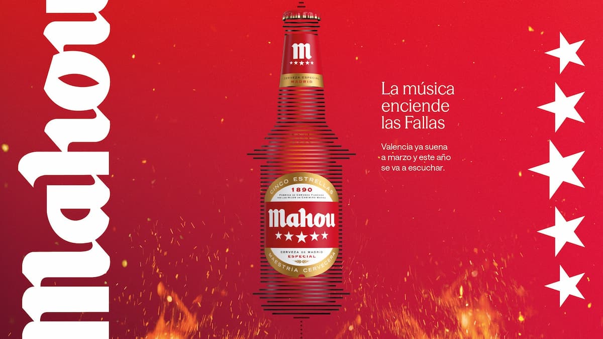 Botella de cerveza Mahou con diseño especial para las Fallas de Valencia, sobre fondo rojo con llamas y texto promocional.