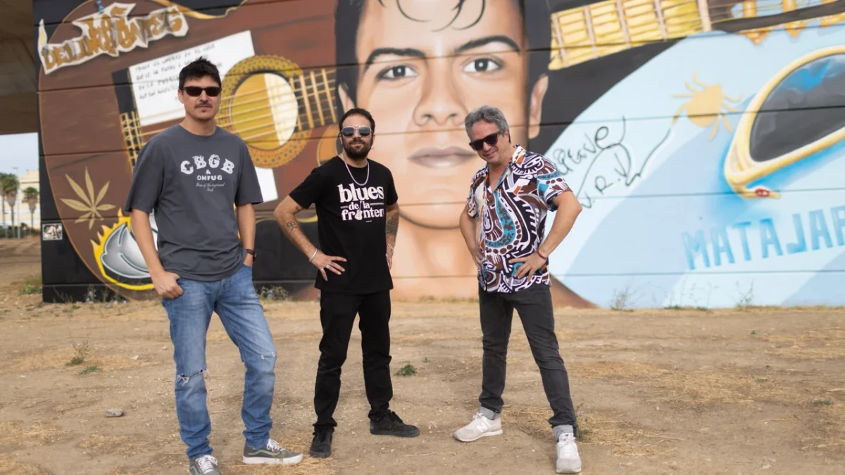 Los Delinqüentes ante un mural dedicado a su música
