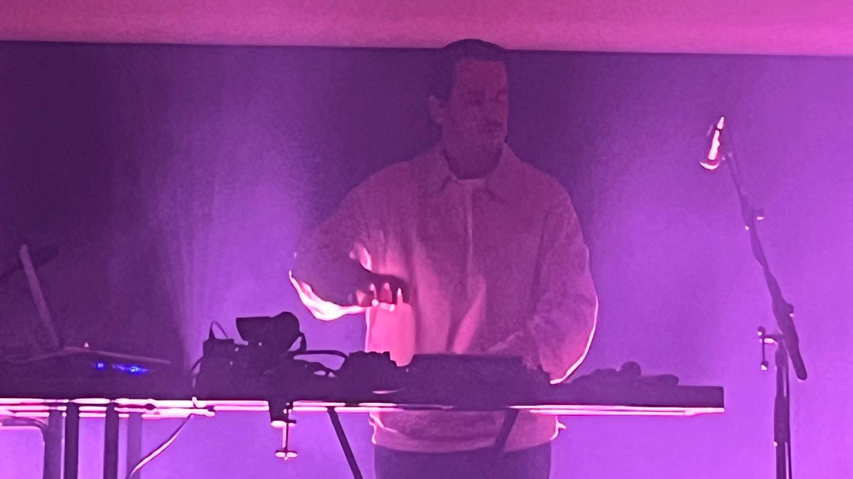 Baiuca en concierto tras su mesa de sintetizadores y percusión electrónica, bañado por luz morada