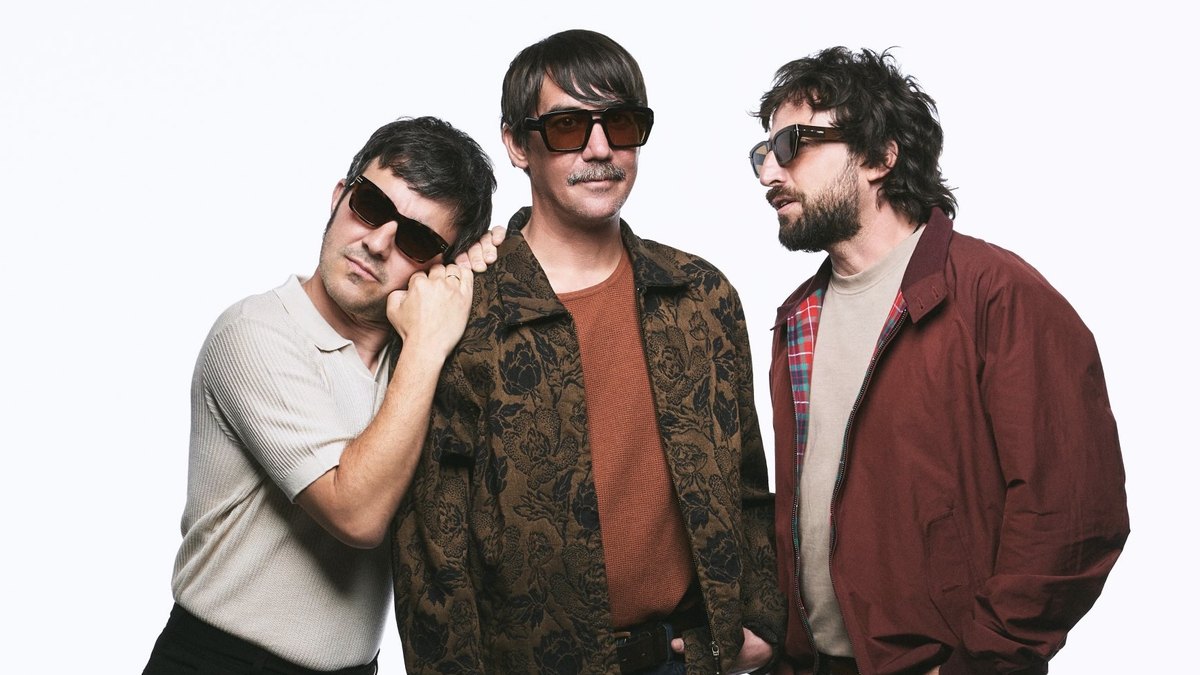 Los tres integrantes de Lori Meyers posan con gafas de sol sobre fondo blanco en una foto promocional