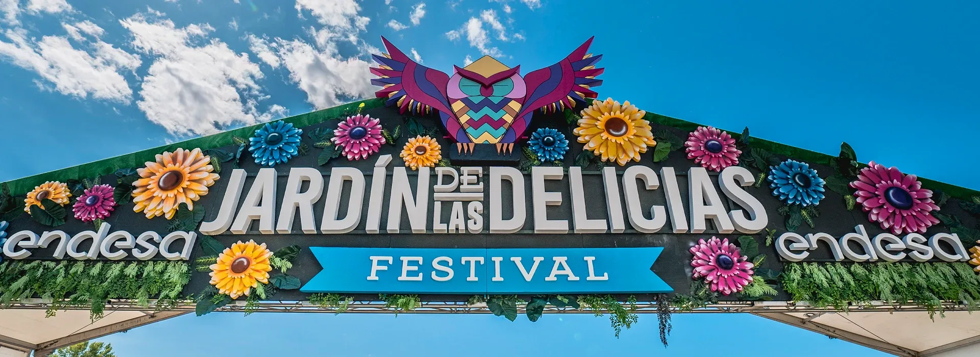 Arco de entrada de Jardín de las Delicias Festival decorado con flores y un búho