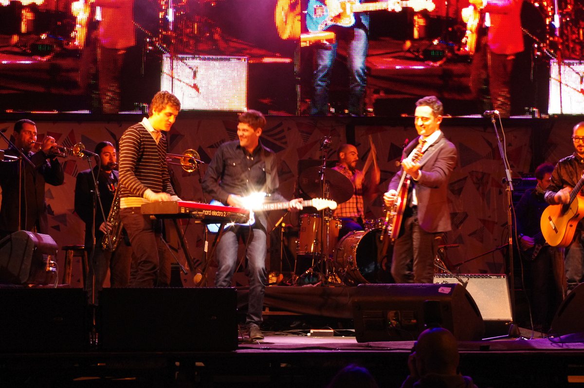 Jorge Drexler a la guitarra junto a su banda sobre un escenario iluminado durante un concierto en 2011