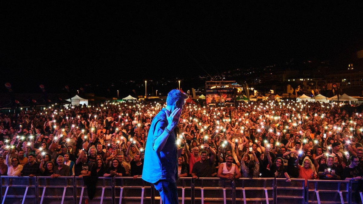 Un artista saluda al público, que ilumina la noche con los móviles, en una edición anterior del festival tinerfeño